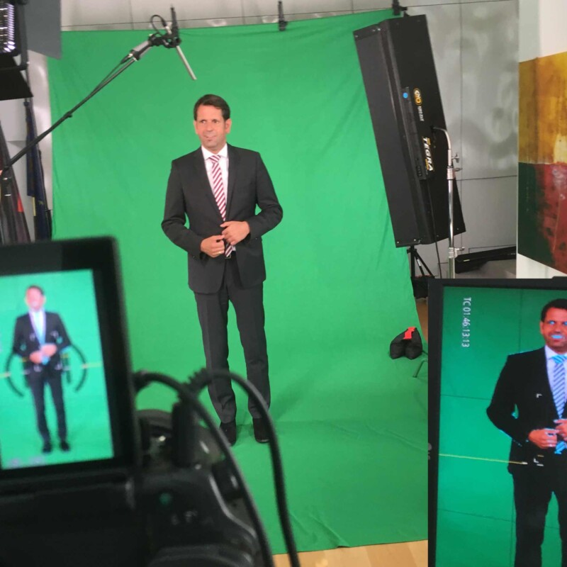 Olaf Lies Ministerpraesident von Niedersachsen steht in seinem Buero, in dem eine GreenBox von 52Gradfilm aufgebaut ist. Er ist auf einigen Kamerascreens zu sehen und wird mit Filmlicht angeleuchtet.